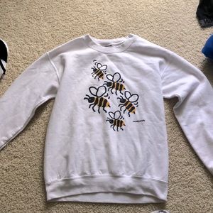 This is a small white crewneck with bees on the front. Brand: Marüshka.